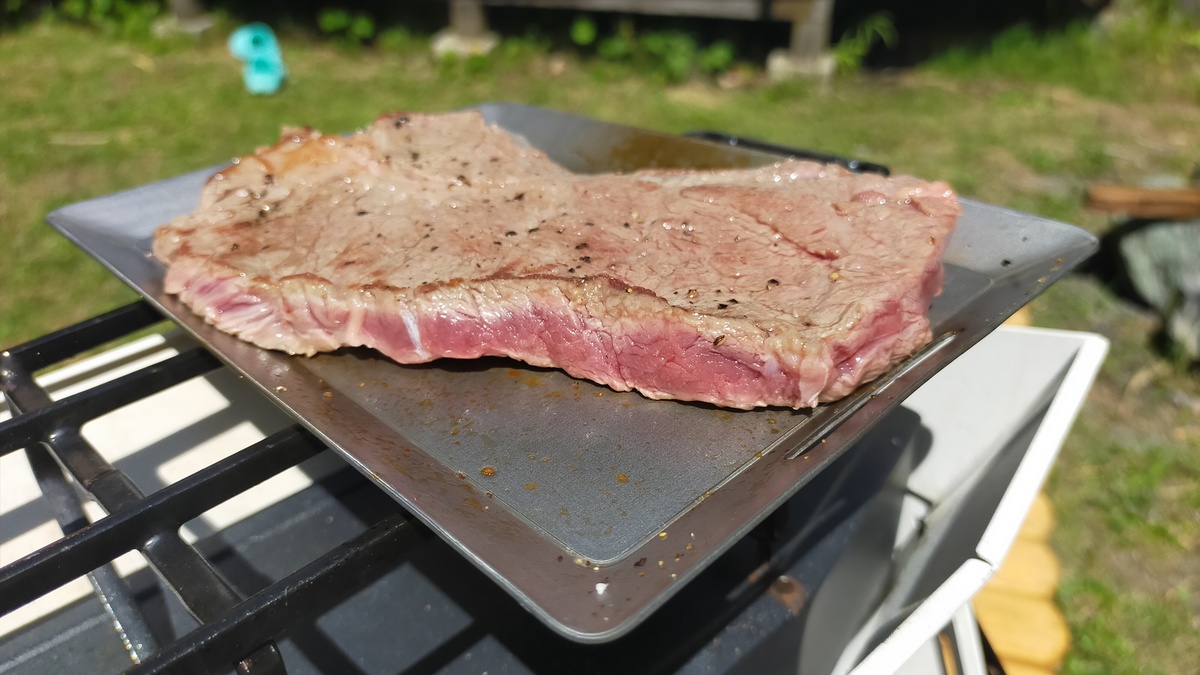 鉄板の上でステーキ肉が焼かれている。