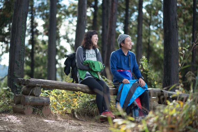 山登り中に休憩する男女