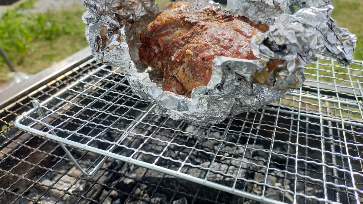 スタンド付き焼き網の上にローストポークがのっている様子。