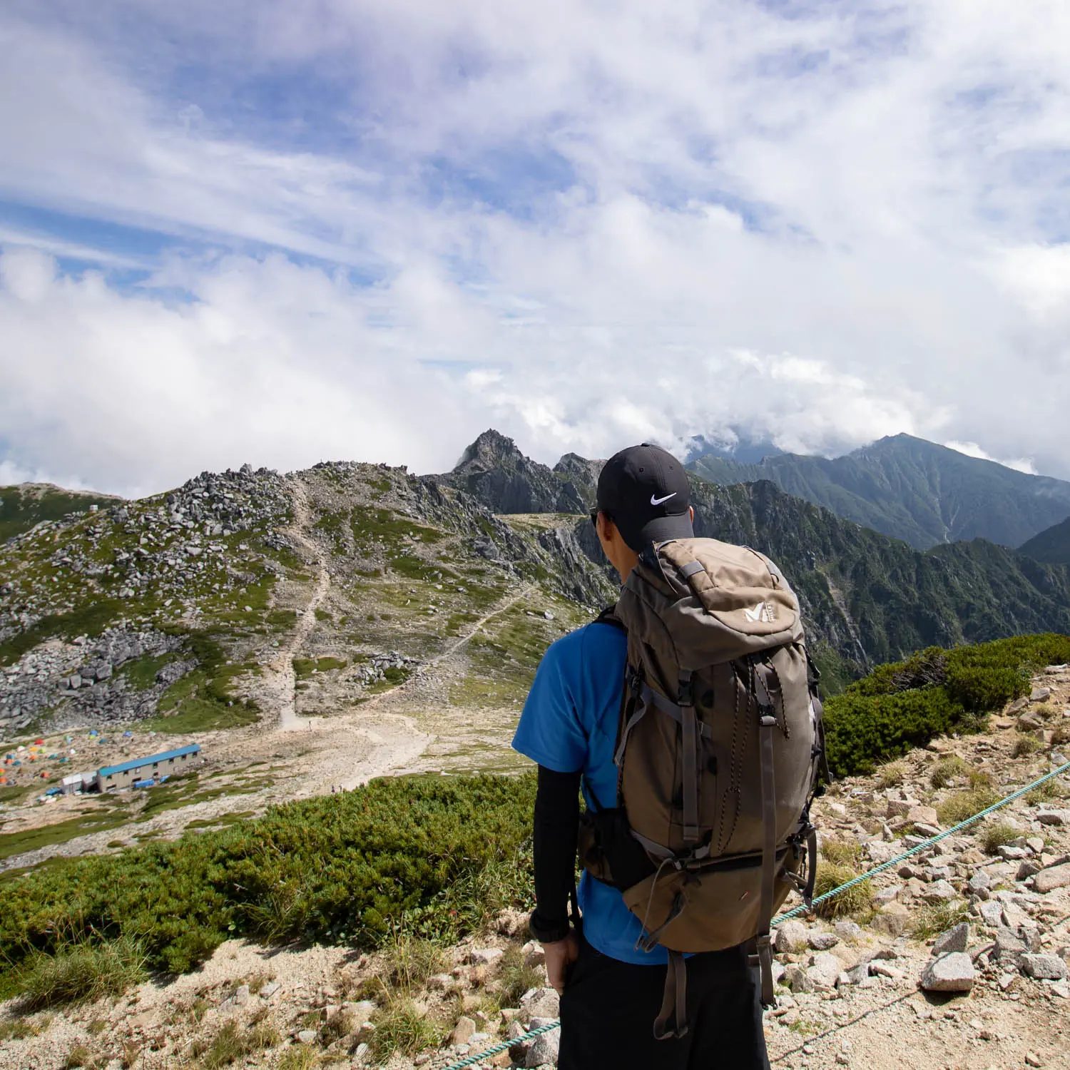 山の景色を見る男性の後ろ姿