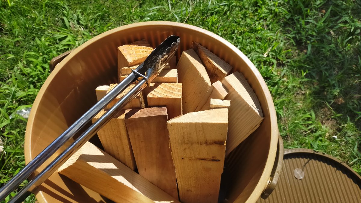 キャンプスツールバケットの中に薪が収納されている。