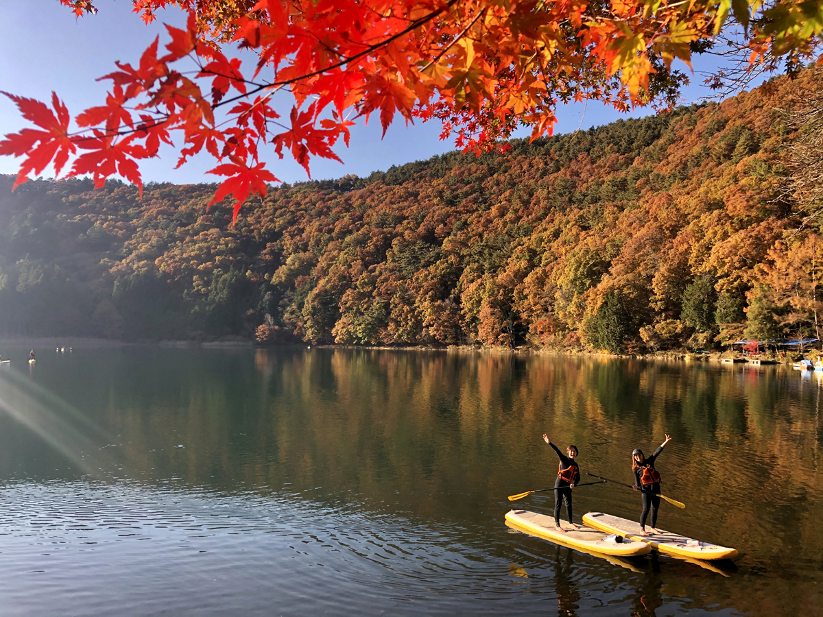 紅葉の季節の四尾連湖でSUPをする人