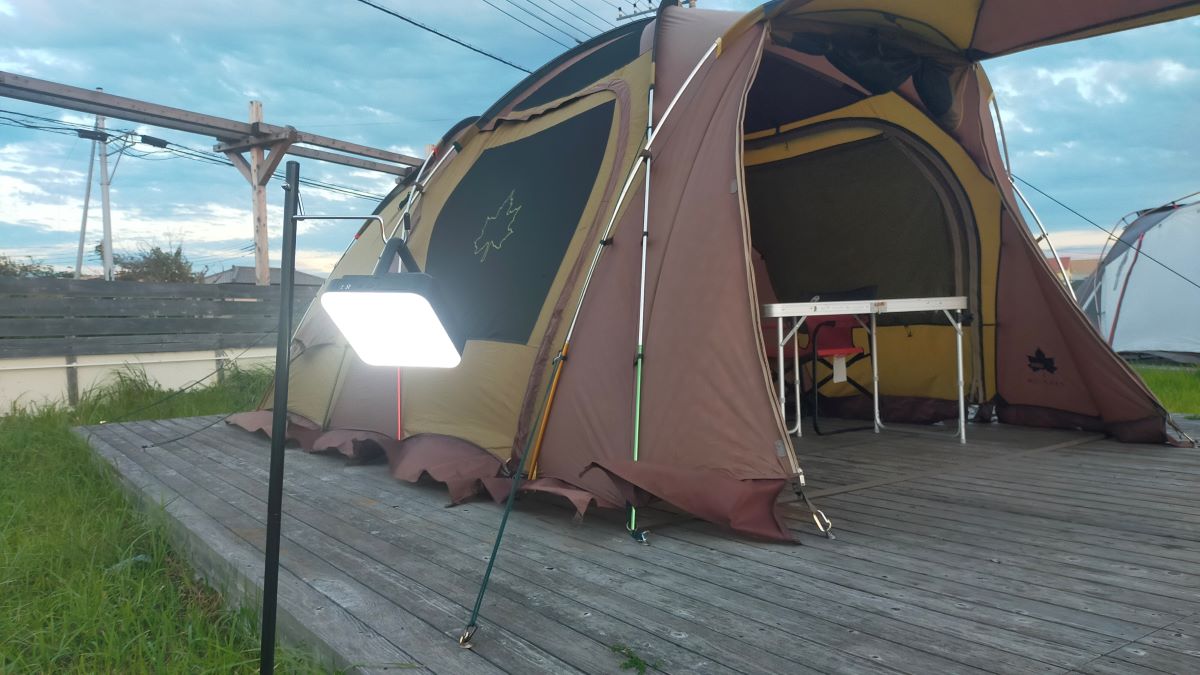 ウッドデッキの上にテントが立っており、離れた場所にランタンが吊り下げられている。