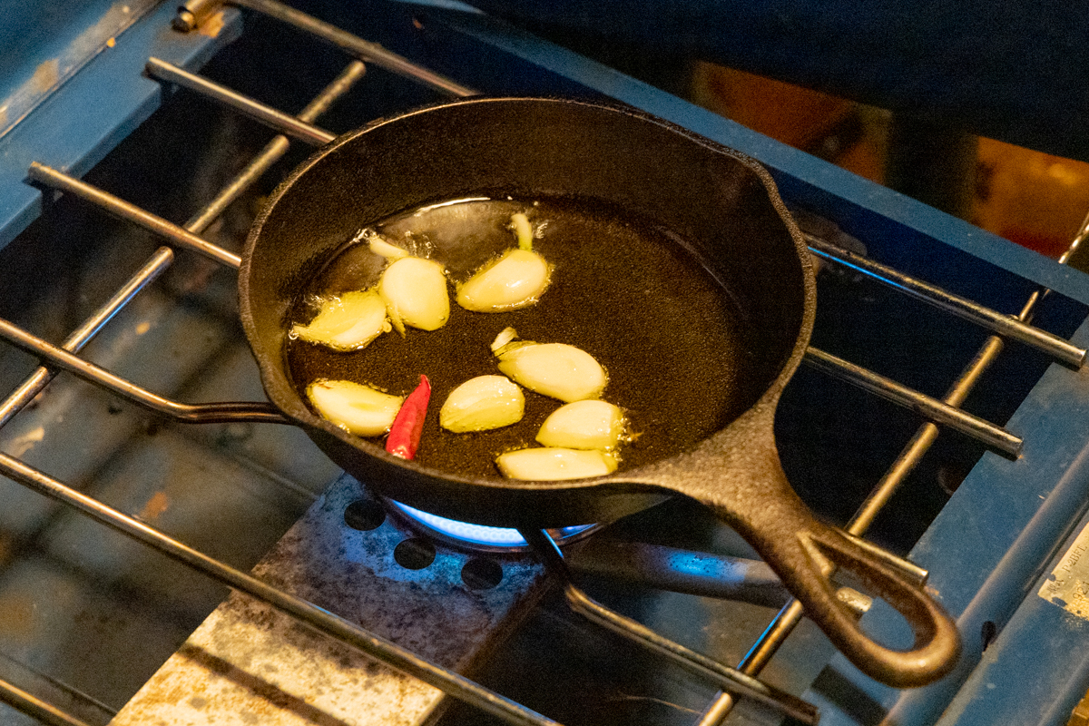 多めのオリーブオイルにタカノツメとにんにくを入れ火を通す