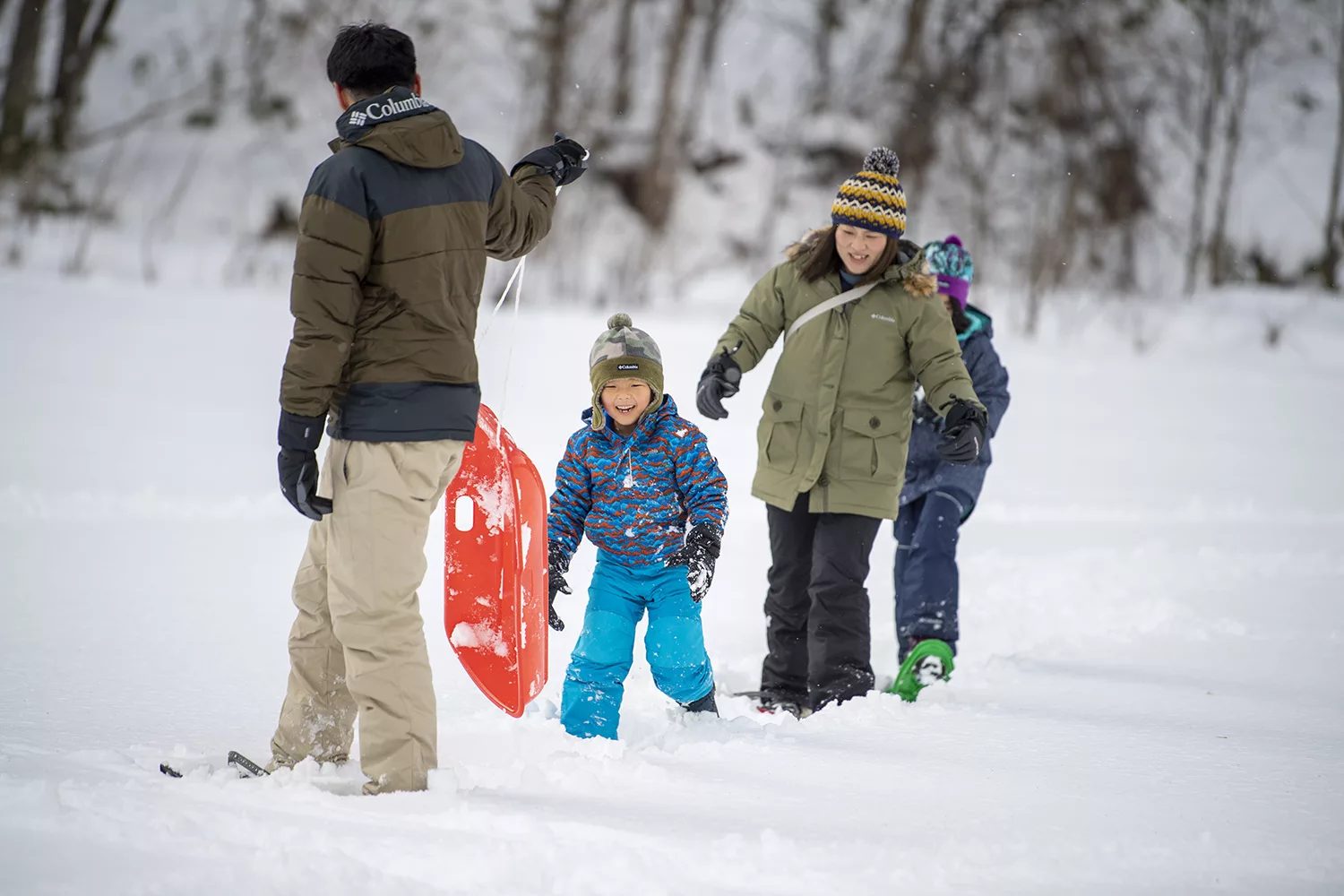 雪の中を歩く家族