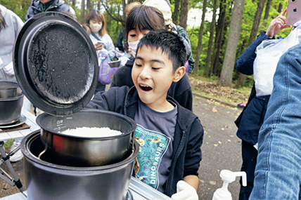 炊けたご飯を見る子供たち