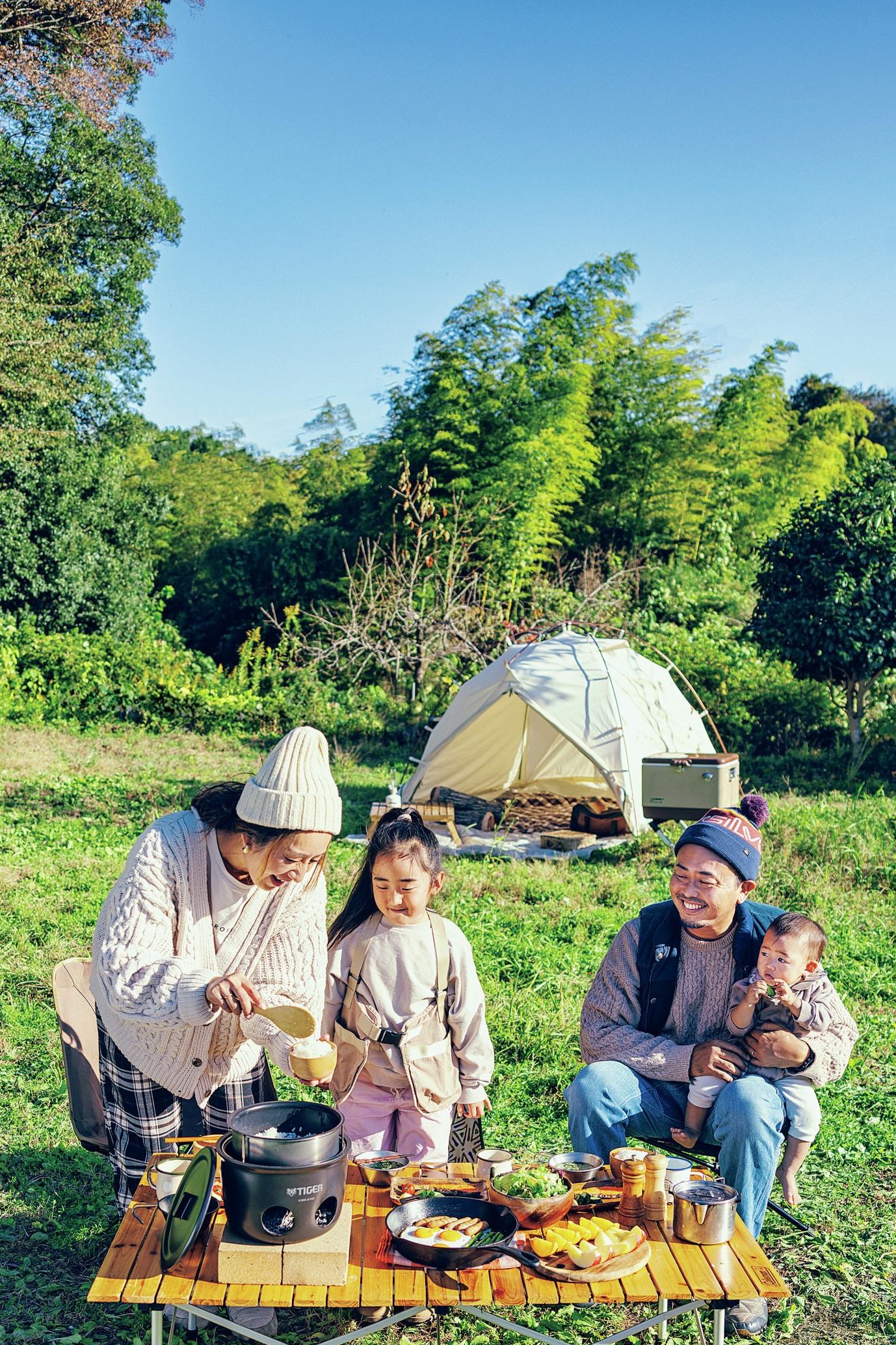 家族でキャンプ　ごはんをよそっている