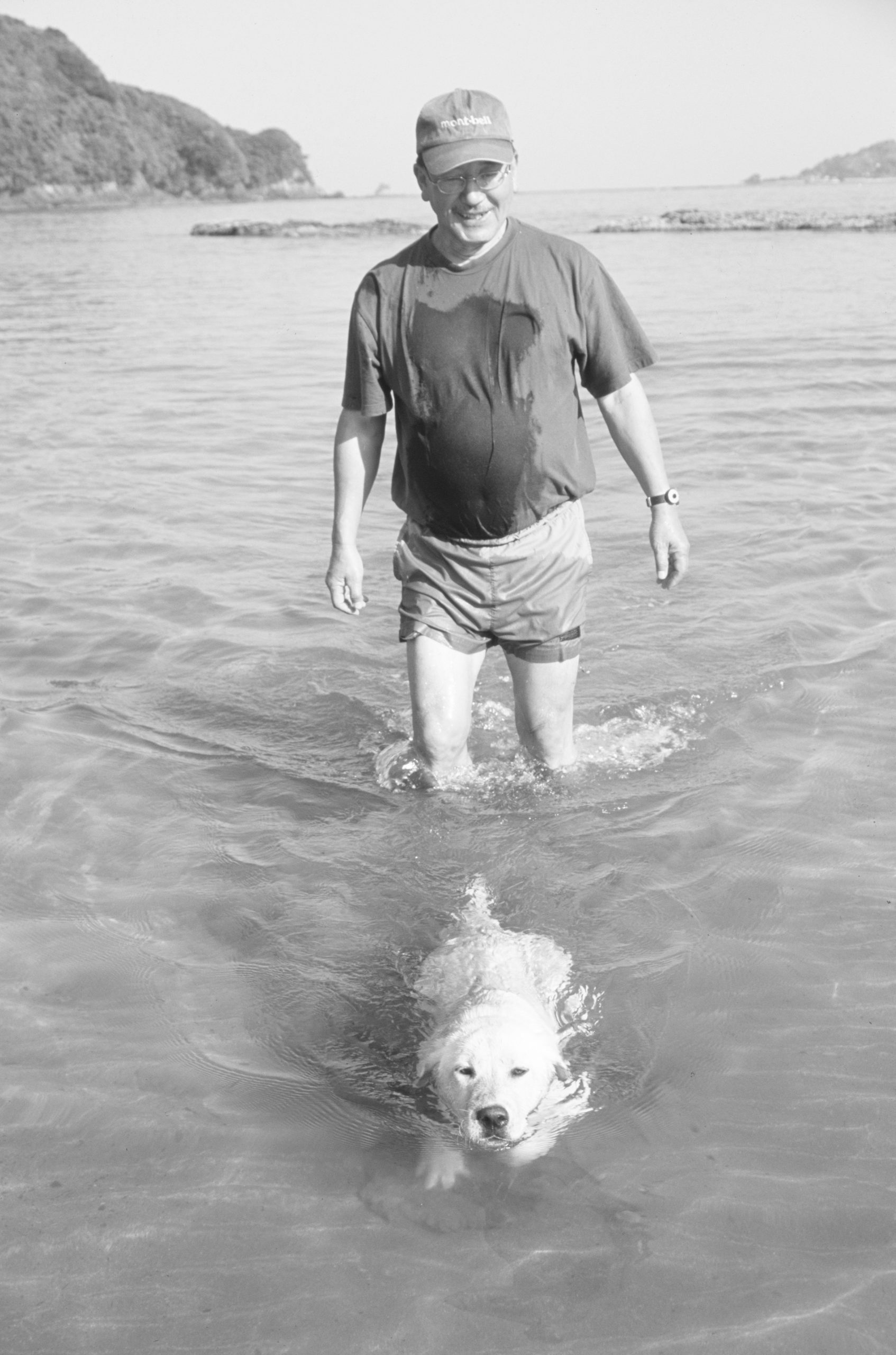 海の中を歩く野田知祐と泳ぐ犬