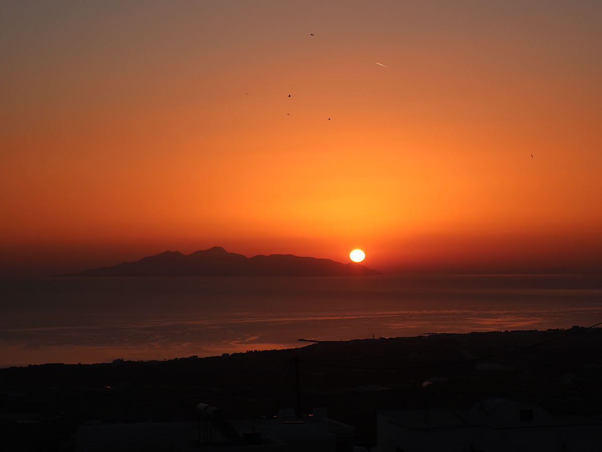 燃えるような色を放つ、サントリーニ島の朝日。