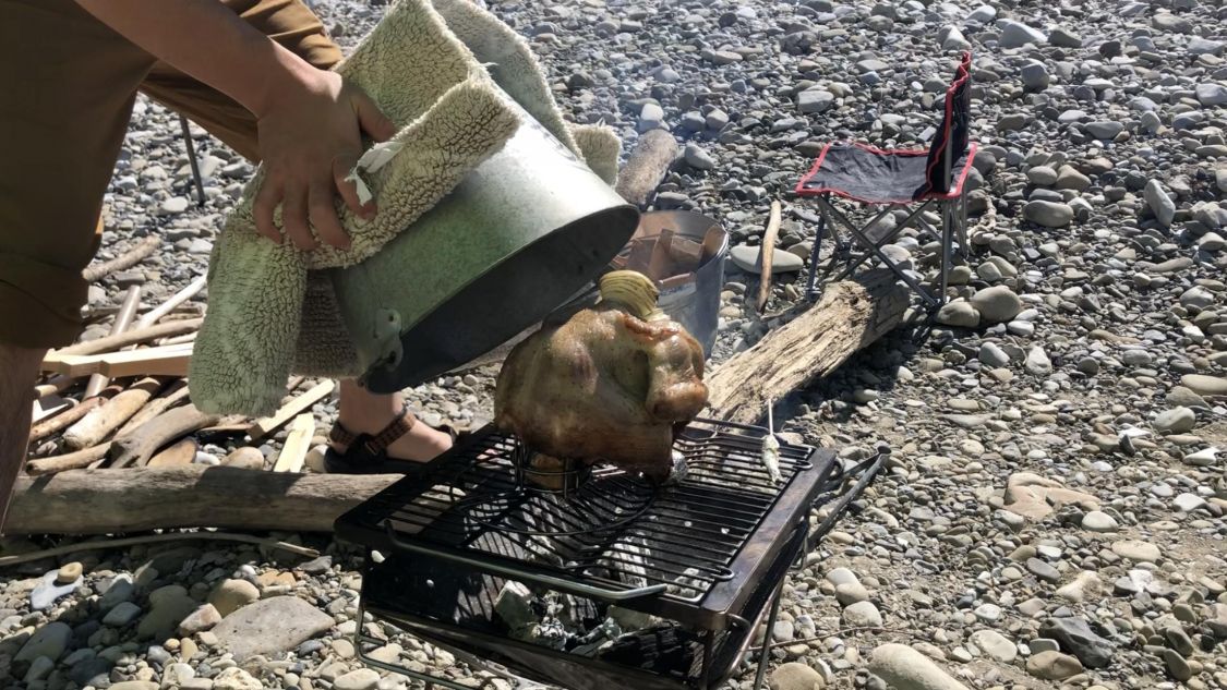 丸鶏にバケツをかぶせて焼く様子