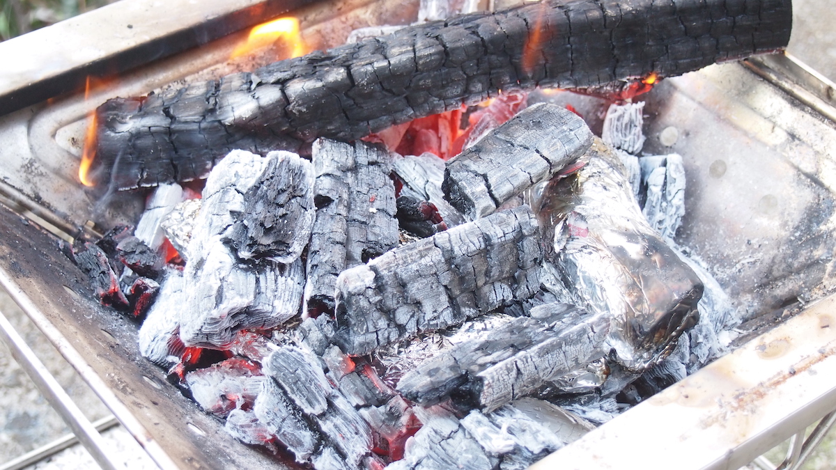 焚き火で焼き芋を焼く