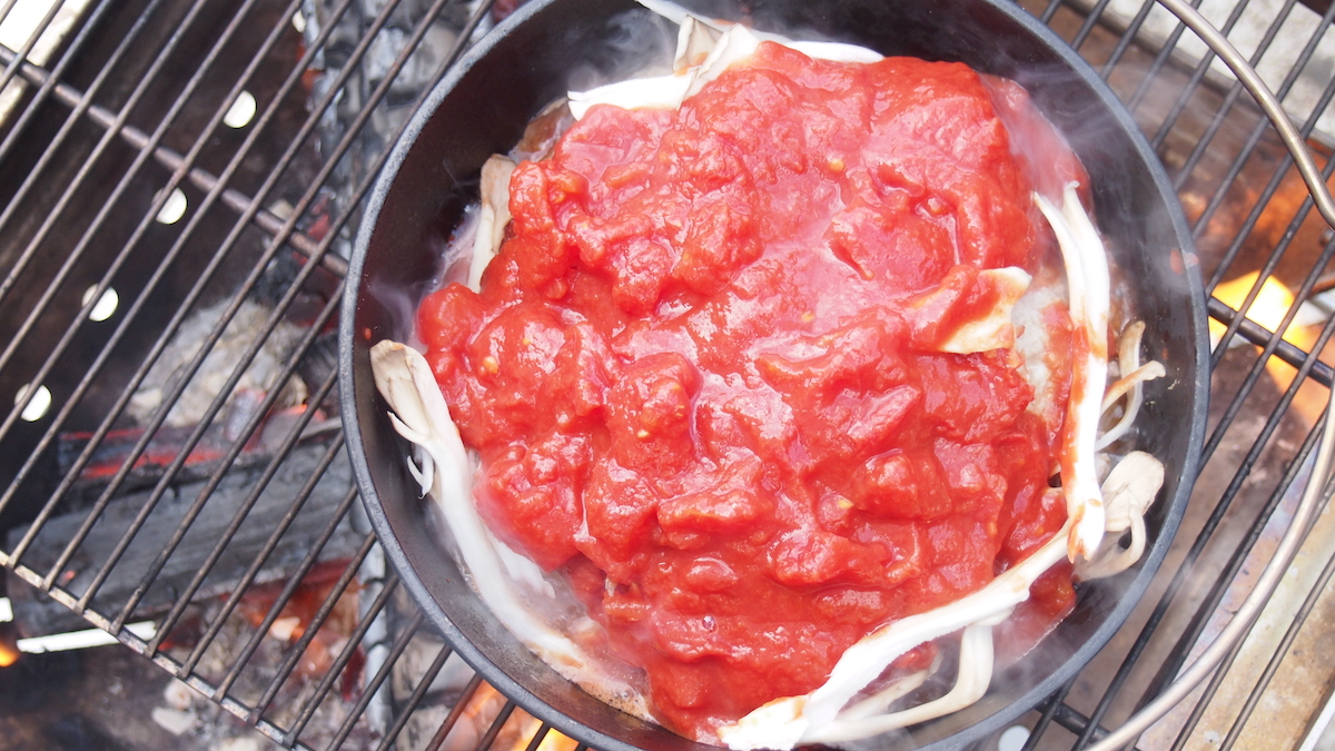 ハンバーグの上にトマト缶をかける