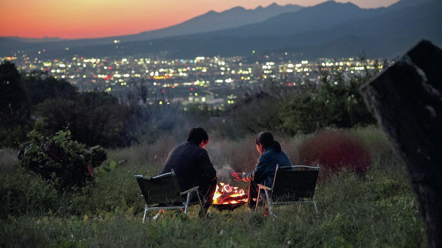 屋外で焚火を楽しむ2人