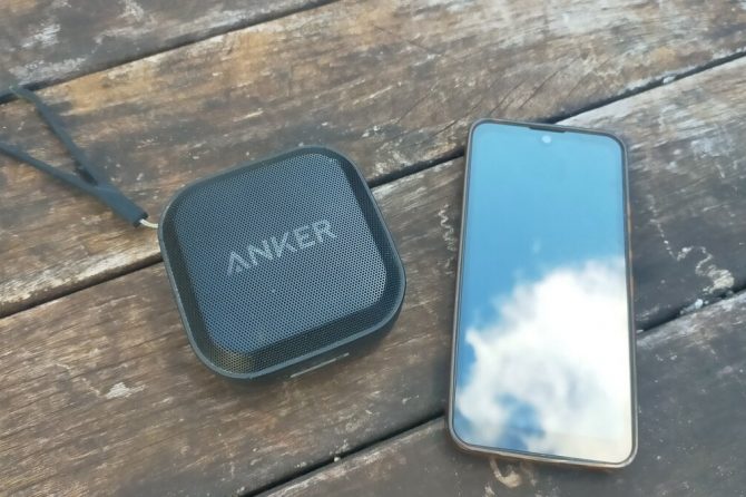 Bluetoothスピーカーとスマートフォンが並んで置かれている。