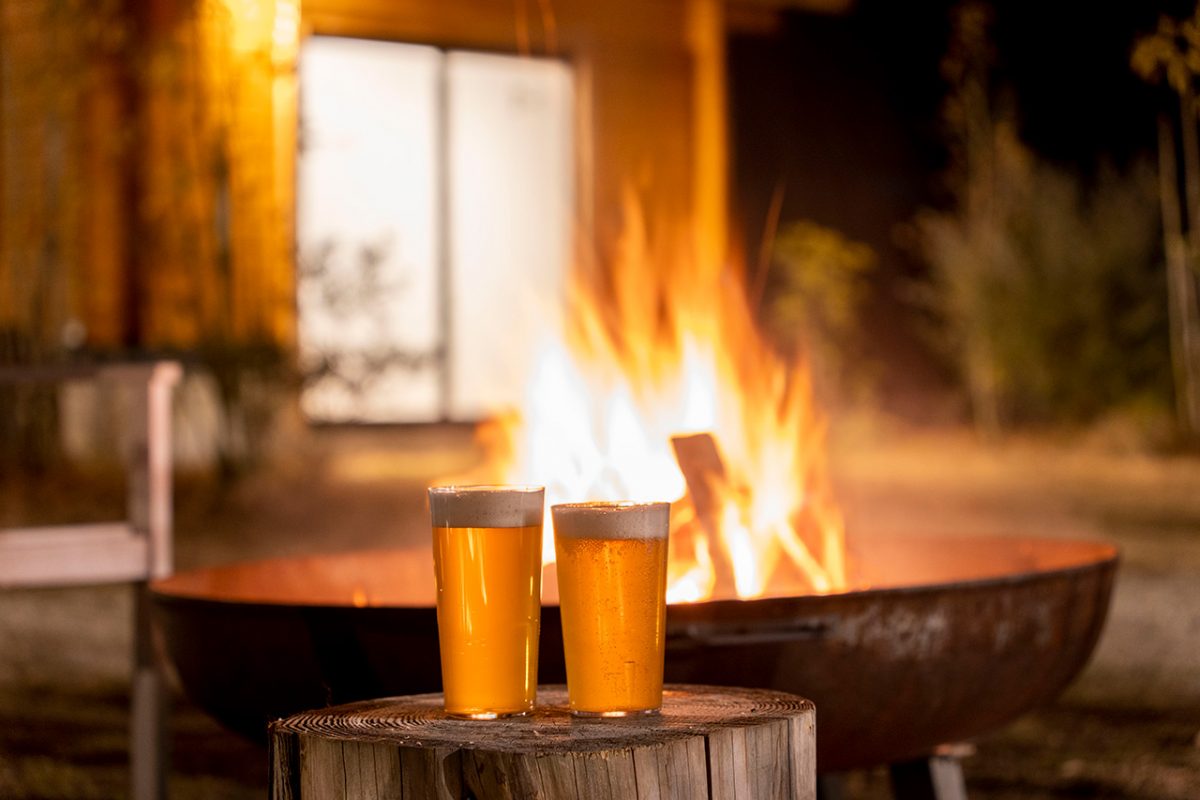 焚き火の前にビールが並んでいる。