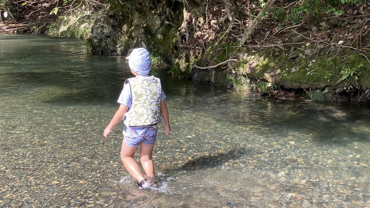 ライフジャケットを着て川遊びする子ども
