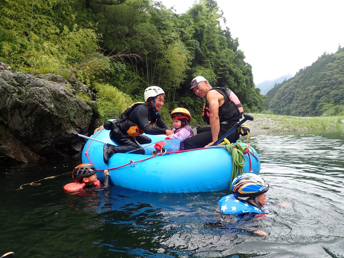 川に浮かんで遊ぶ子供たち