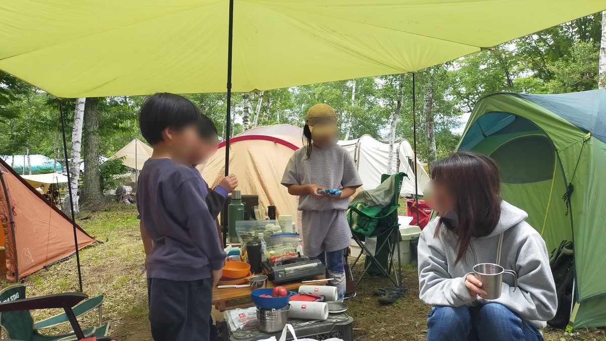 テント前で家族がくつろいでいる様子。