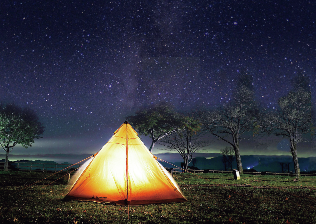 満天の星が広がる夜のキャンプ場の風景。