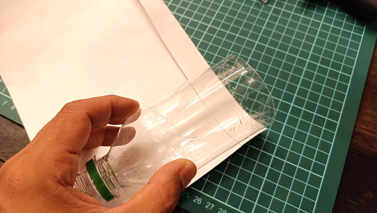 ペットボトルに紙を巻いている様子。