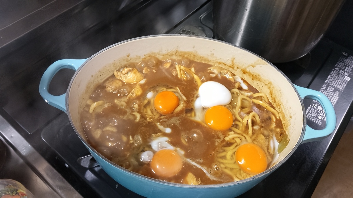 鍋で大量の煮込みうどんを調理している。