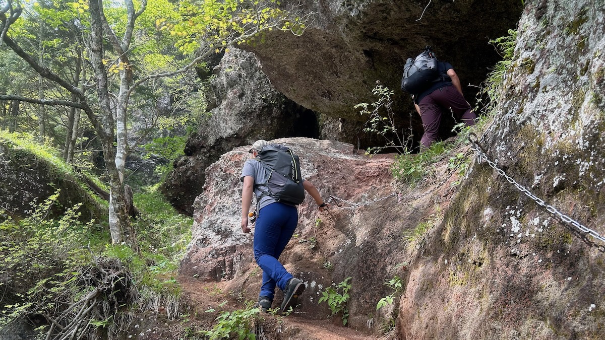 ザックを背負って岩山を登る。
