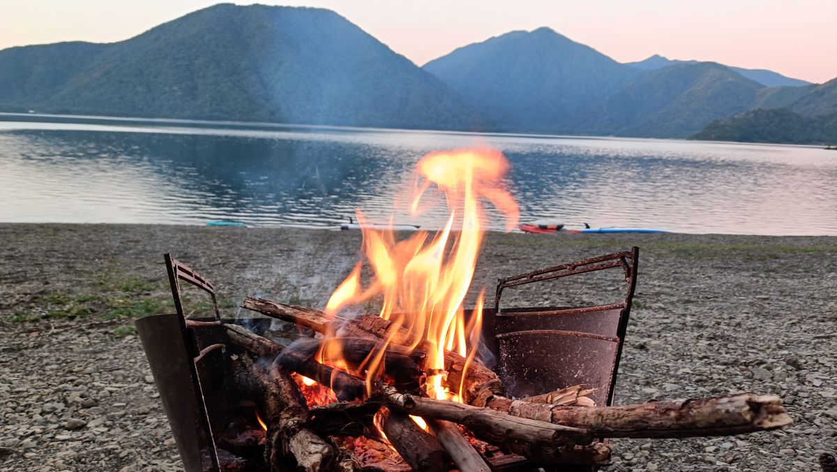 湖の前で焚火をしている様子。