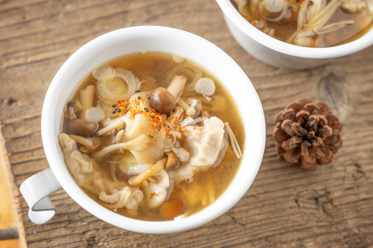 長ネギや七味唐辛子を散らしたそばすいとんのきのこ汁