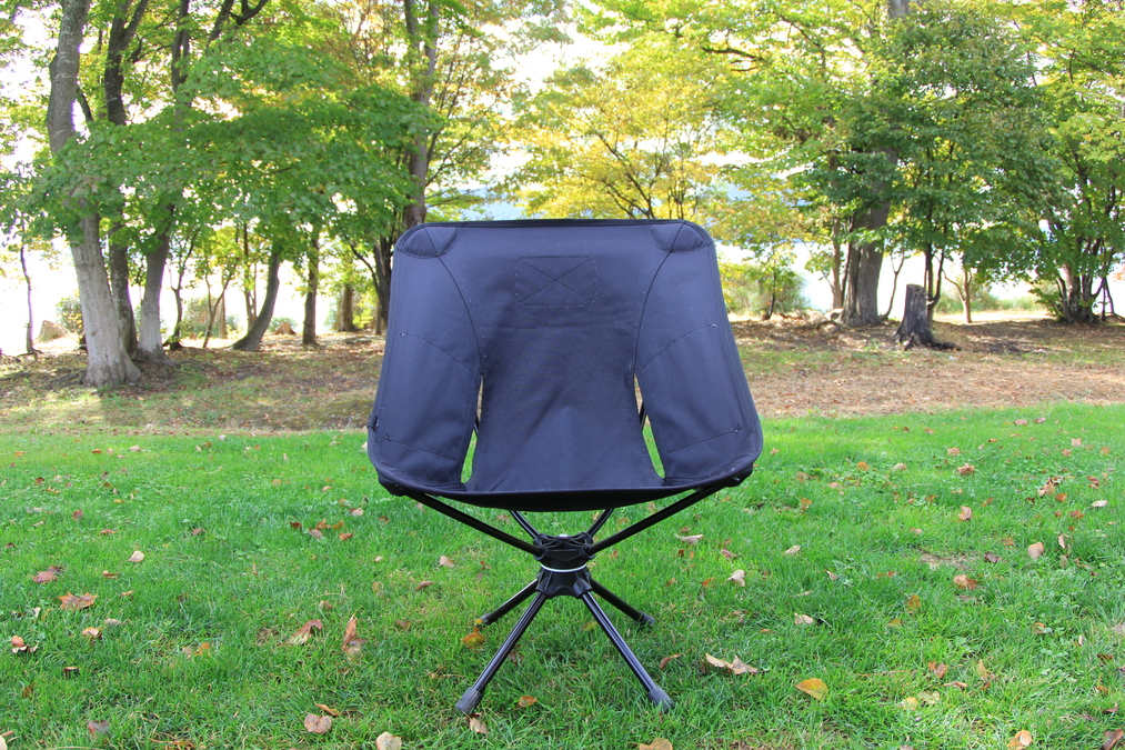 芝生サイトに設置された「Helinox タクティカル スウィベル チェア」の全体像。黒のシートと無骨なデザインが印象的。