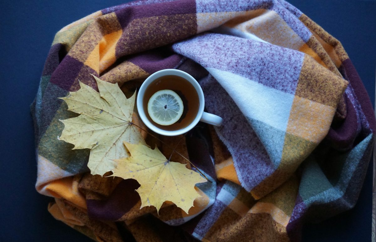 チェック柄の毛布とカップと落ち葉