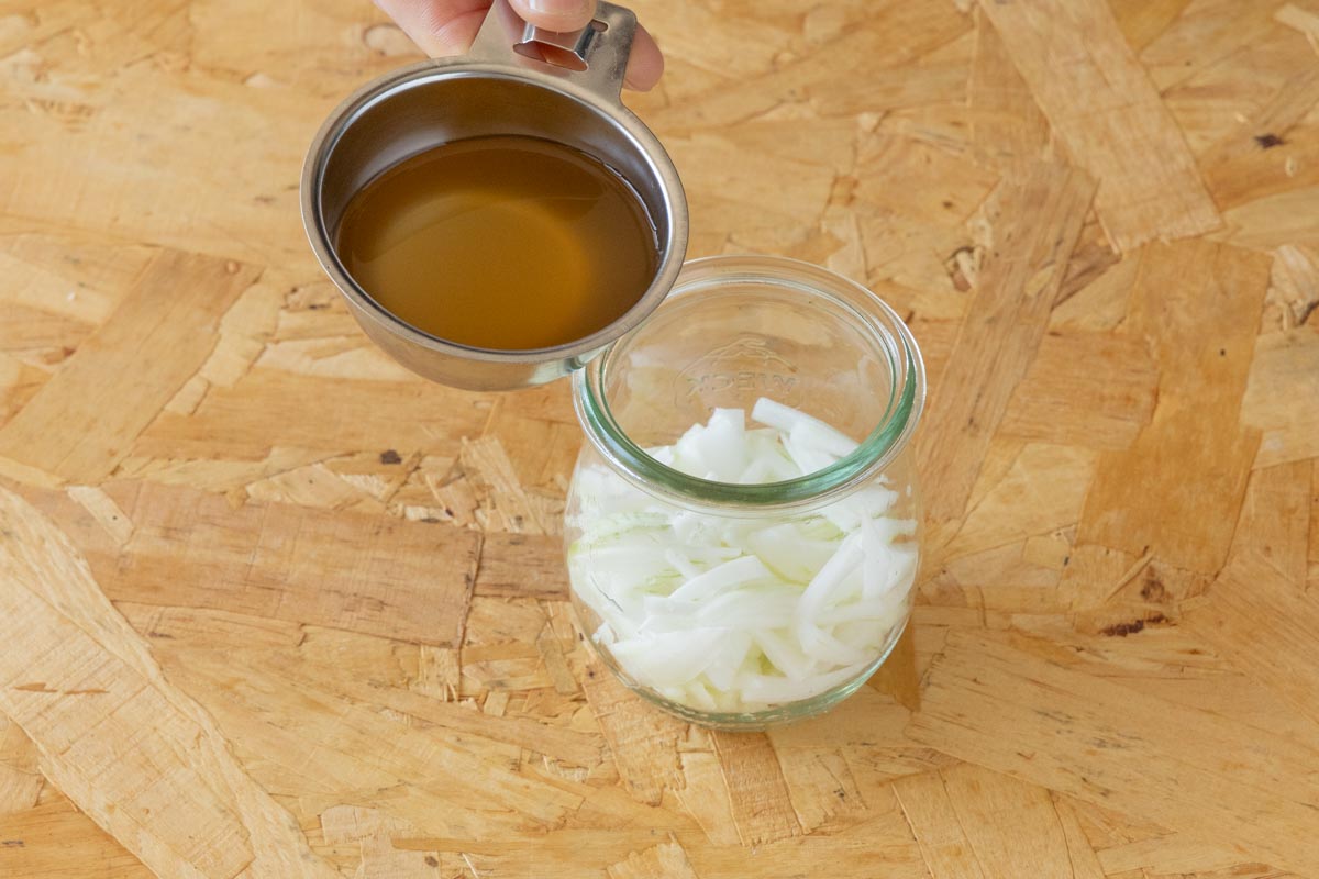 スライスした新玉ねぎに酢を加える
