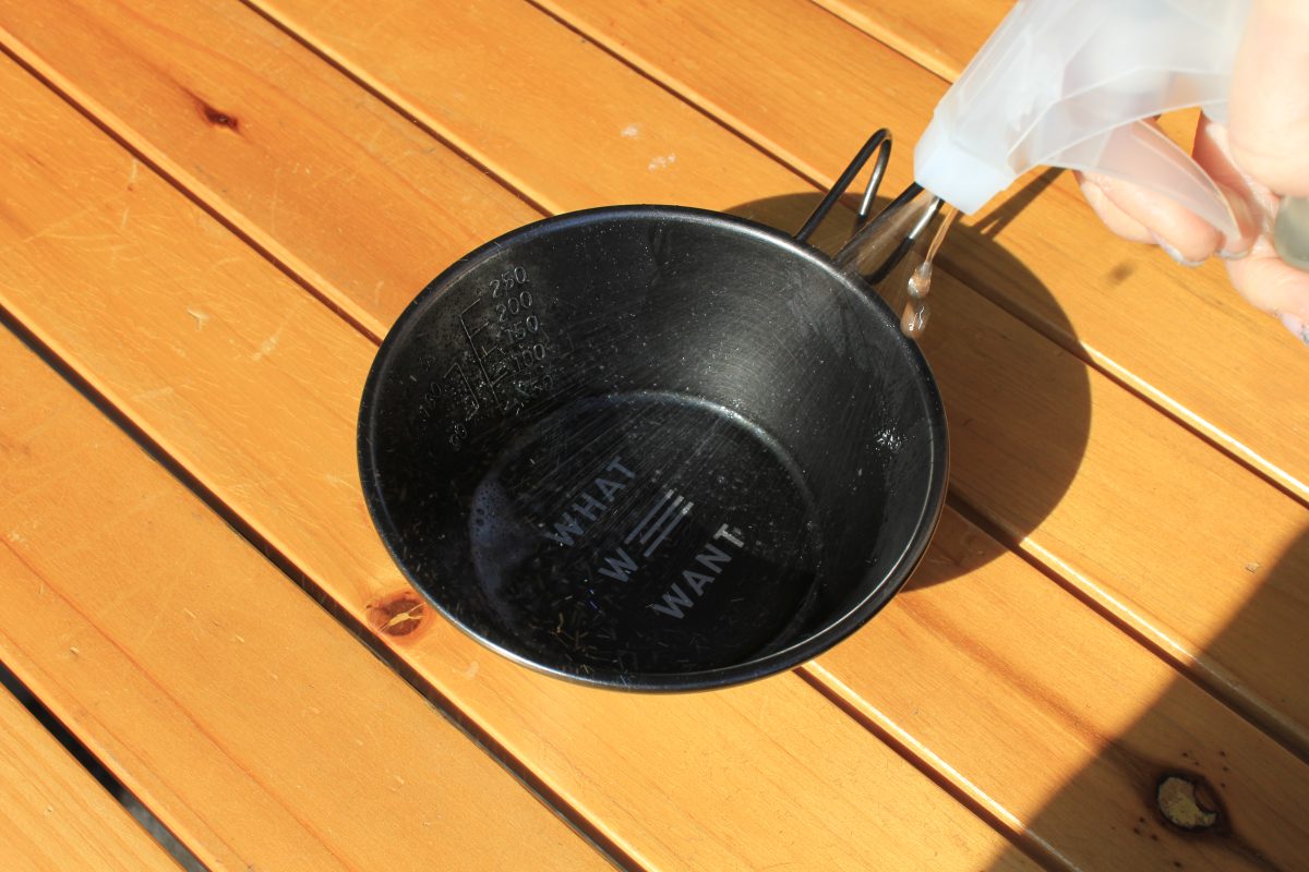 シェラカップの内側にECO KITCHEN CLEANERをスプレーしている様子