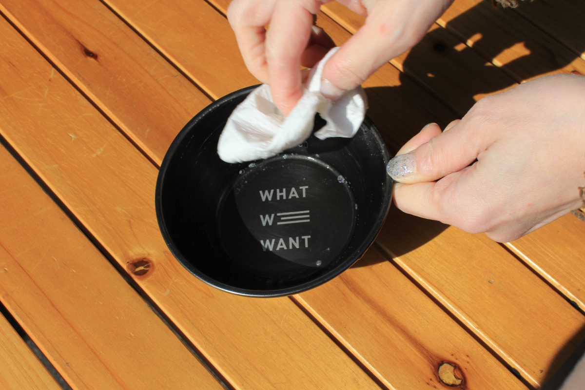 クリーナーをスプレーした後のシェラカップをキッチンペーパーで拭き上げている様子