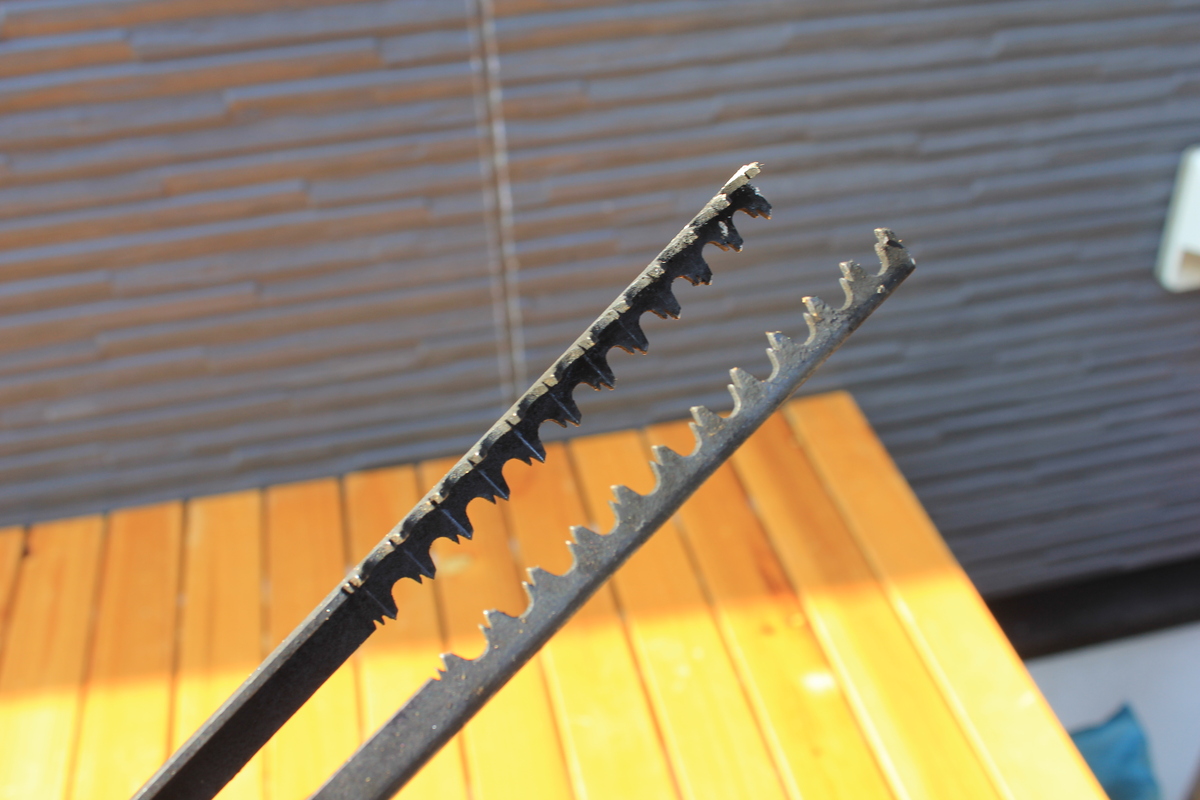 炭や灰が付いた火ばさみの先端部分をアップで写した写真。