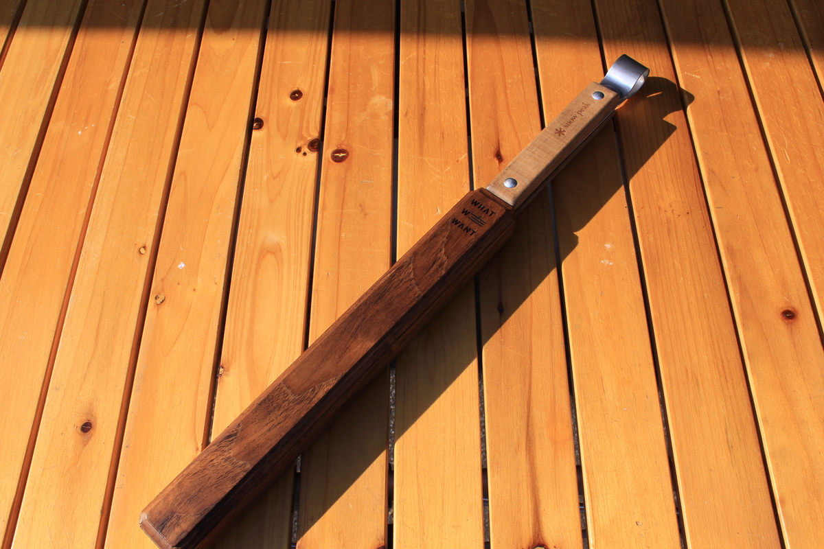 スノーピークの火ばさみを木製ケース「WWW_SAYA」に収めた状態を斜め上から写した写真。