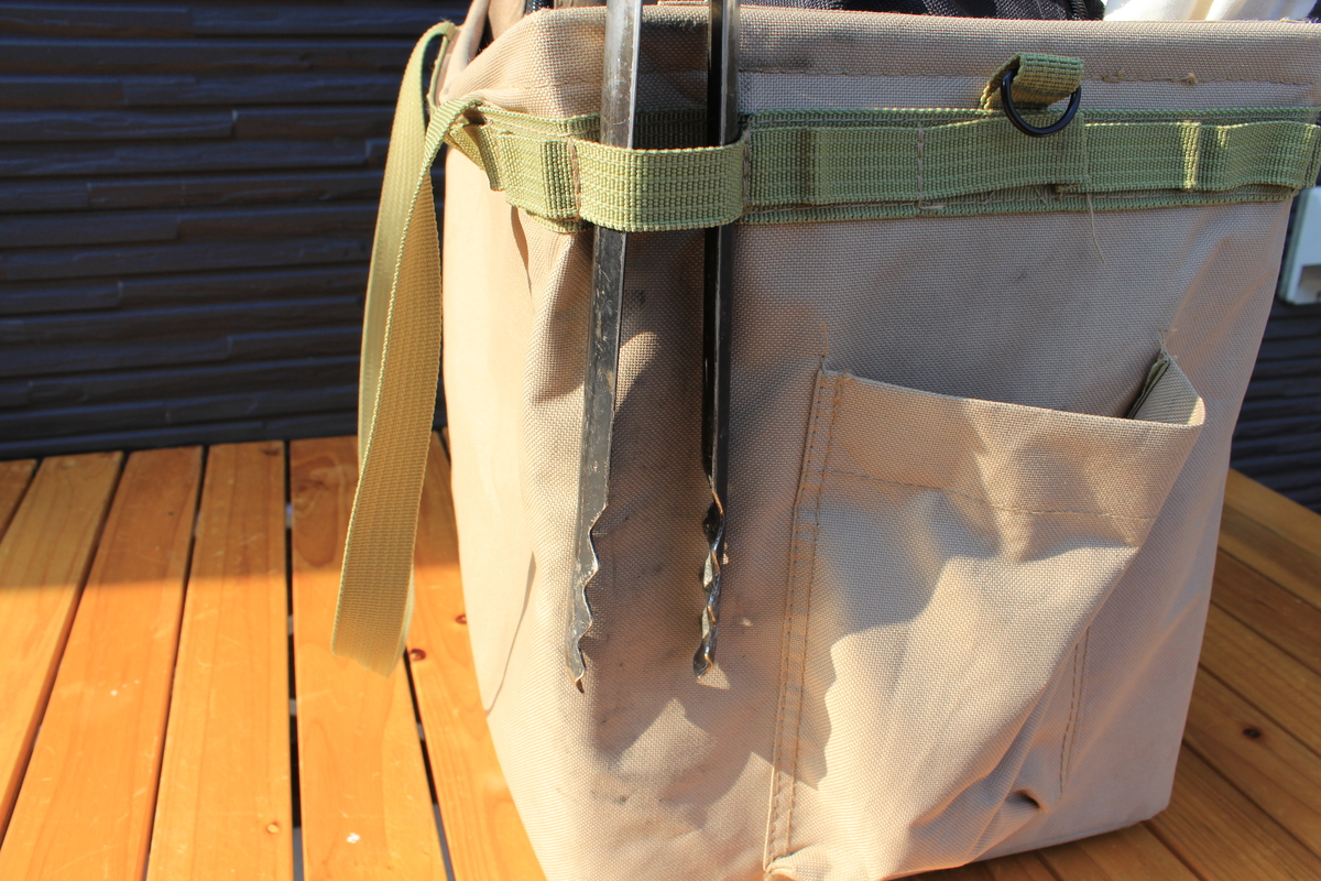 火ばさみをケースなしで布製バッグの外側に差し込んだ状態の写真。