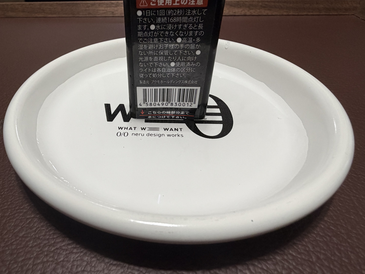 皿に入れた水にアクモキャンドルを浸している様子