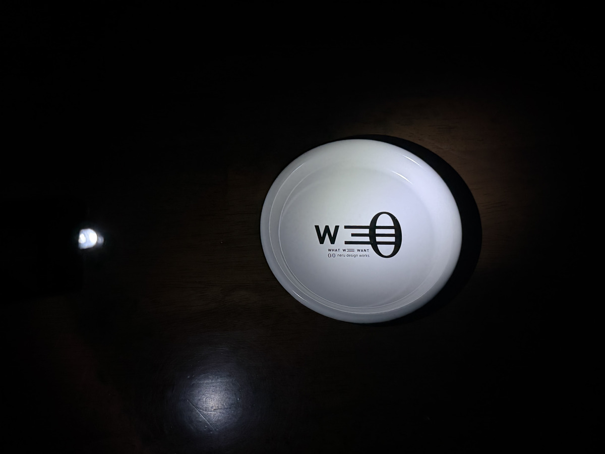 暗い室内で点灯したアクモキャンドルがお皿を照らしている様子