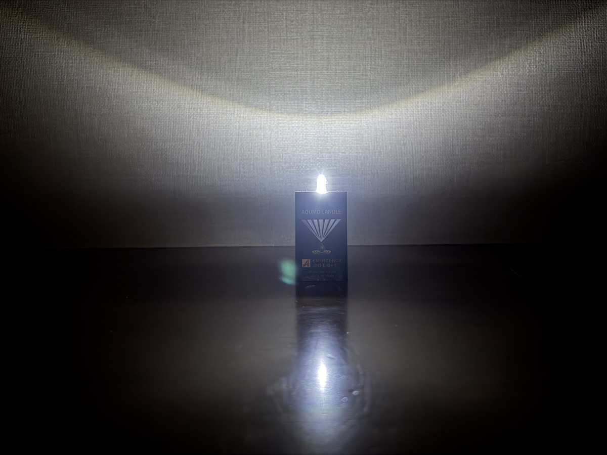 暗い室内で点灯したアクモキャンドル本体と光の広がり