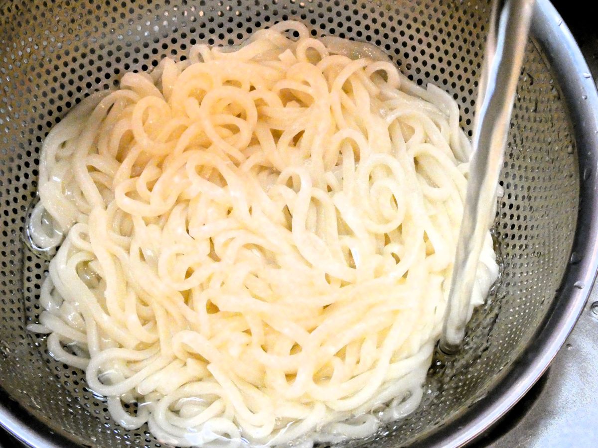 茹でたうどんを水でしめる