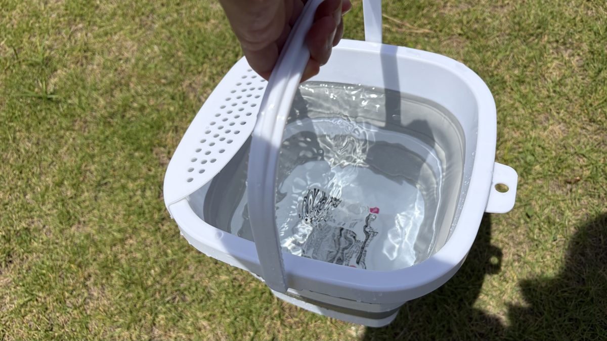 バケツに水を入れて運ぶ様子