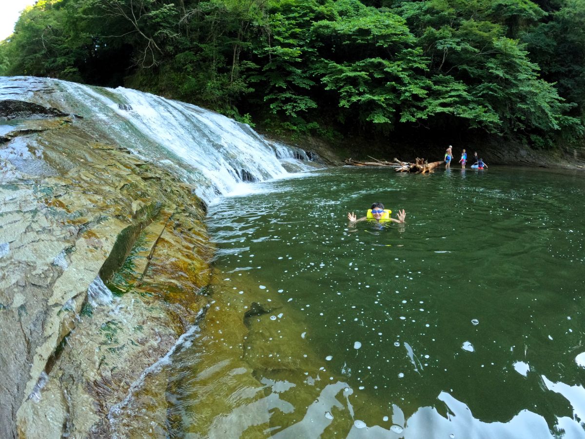 滝つぼ近くで遊ぶ家族