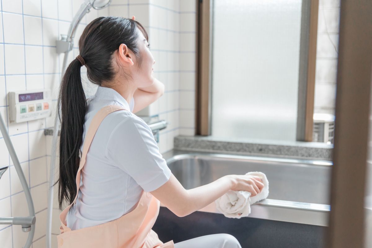 お風呂掃除をする女性